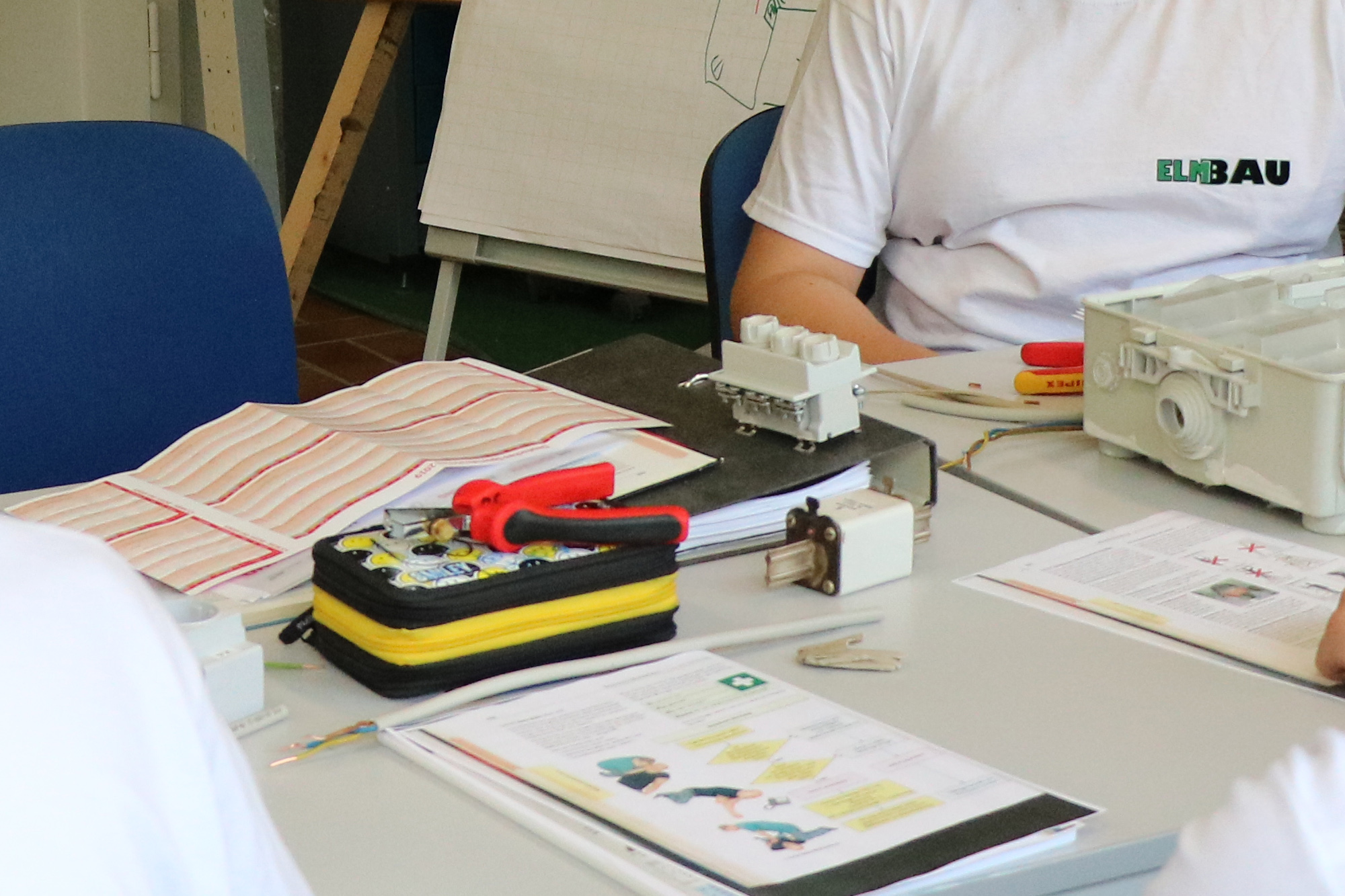 ElmBau - Ausbildung zum Elektroniker, Azubis verkabeln einen Stromkreislauf im Ausbildungszentrum