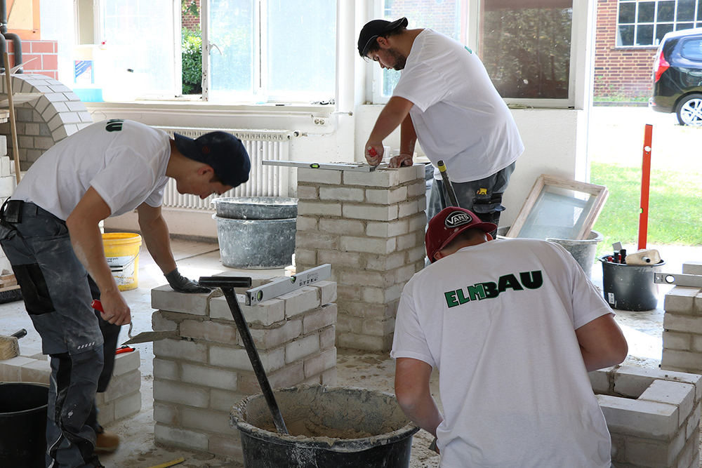 ElmBau - Ausbildung zum Maurer, Azubis maurern einen Schornstein im Ausbildungszentrum